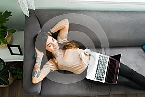 Hispanic young woman smiling while resting at home