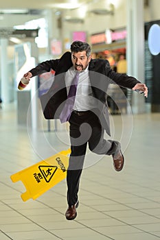 Hispanoc Businessman Falling on Wet Floor