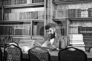 Historian sits in library and reads old books.