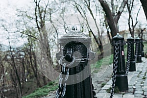 Historic black metal chain fence against an ocker colored