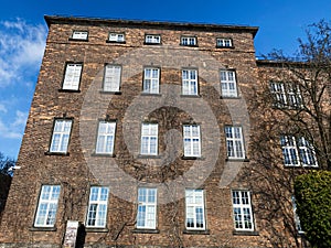 Historic brick building with large windows under a blue sky in Krakow photo