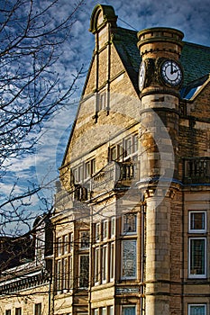 Historic building with clock tower under blue sky with clouds in Harrogate, England