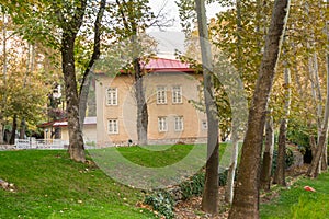 Historic building hidden in the golden forest in autumn with background of mountain in Sa`dabad palace Complex, built by the Qaja photo
