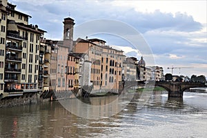 Historic buildings, churches overlooking the Arno River and a bridge that crosses it in Florence.