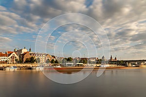 Historic buildings in Szczecin behind the Odra River. Blurry ship Long exposure
