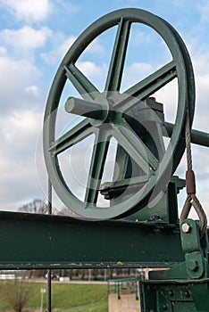Historic cast iron lifting wheel against the blue sky