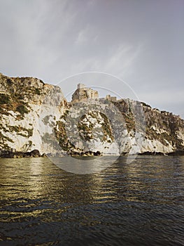 Historic castle ruins on a cliff over water at the Tremiti Islands in Puglia, Italy