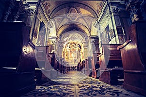 Historic catholic church: Wooden pews in a row and altar width crucifix