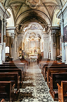 Historic catholic church: Wooden pews in a row and altar width crucifix