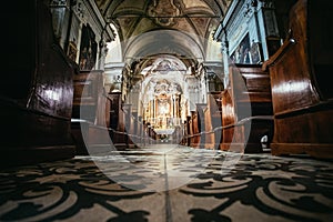 Historic catholic church: Wooden pews in a row and altar width crucifix