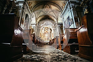 Historic catholic church: Wooden pews in a row and altar width crucifix