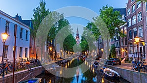 Historic Dutch homes and boats along canal in front of De Oude Kerk photo