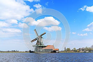 Historic Dutch Windmill in Zaanse Schans on the Zaan River in the Netherlands photo