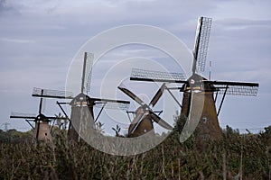 Historic dutch windmills in Kinderdijk in a cloudy autumn day. Unesco site.