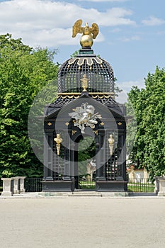 A historic gazebo decorated with sculptures, gold Griffin sculpture on the roof  in the gardens of the Branicki Palace,