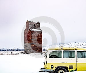 Historic grain elevator and old tractors and trucks in the snow. Dorothy,Alberta,Canada