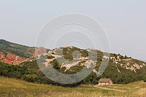 The historic home of Henry Persse nestled among dramatic red sandstone rock formations and prairie grasses