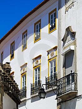 Historic house in Evora, Portugal. Windows with balconies.