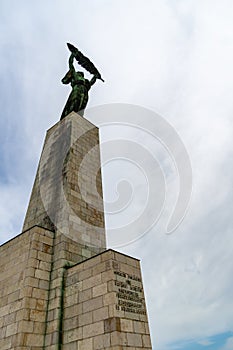 The historic Liberty Statue upon Gellert Hill in front of a cloudy sky in Budapest, Hungary