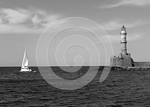 Historic Lighthouse of Old Port of Chania with a Sailing Boat, Crete Island, Greece in Monochrome