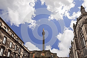 Historic Mercat Cross with golden unicorn stands in Edinburgh Parliament Square against stone buildings