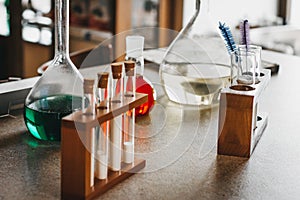 Historic old pharmacy bottles  laboratory beakers on a dark wooden table. Ancient medical laboratory