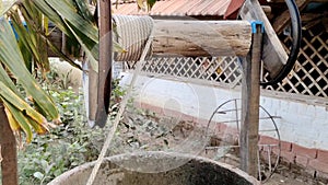 Historic, old traditional water well with rope and pulley in a village in Andhra pradesh, India.