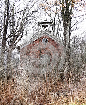 Historic red brick building in overgrown brush visible in winter near Evans Corners Tyre NYS