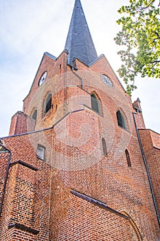a historic red brick church tower against the sky
