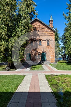 Historic Red Palace in Uglich, Russia, featuring intricate brick patterns and surrounded by lush greenery photo