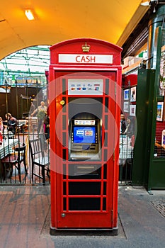 Historic red phone box used as a cash machine in London, UK