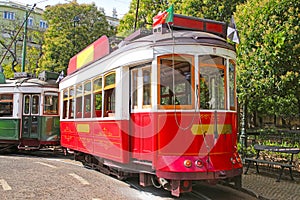 Historic red tram against trees, Lisbon, capital city of Portugal