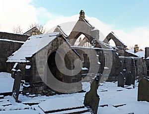 Historic ruined medieval church in heptonstall in west yorkshire cover in snow in winter with a blue sky