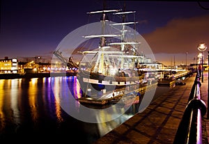 Historic sail ship docked in the city at night