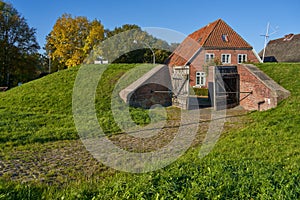 Historic sleice gate and a brick house in Stadland, Germany