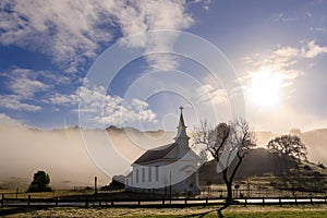 Historic small town church in West Marin County in fog and morning sun photo