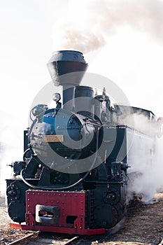 Historic steam train passing an old Romanian village