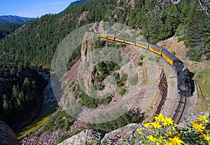 A steam train along a river in Colorado