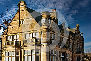 Historic stone building with clock tower under blue sky in Harrogate, England
