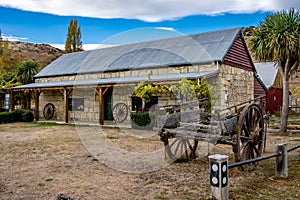 A historic stone-built building and old horse cart in the South Island of New Zealand