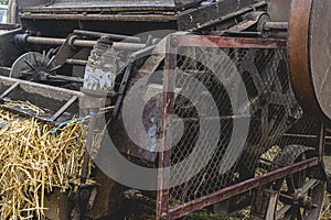 Historic straw press following a threshing machine in operation. The wheel turns and shows motion blur