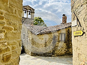 Historic street in the Tuscan town of Cortona with a view of the Church of San Cristoforo
