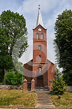 The historic tower of the Gothic red brick church in the village of Sokola Dabrowa