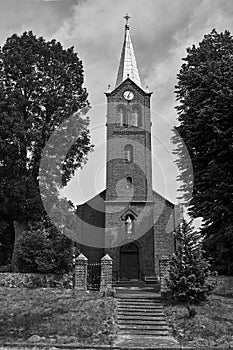 The historic tower of the Gothic red brick church in the village of Sokola Dabrowa