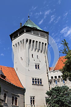 Historická věž zámku Smolenice s v Malých Karpatech, Slovensko. Modrá obloha s bílými mraky
