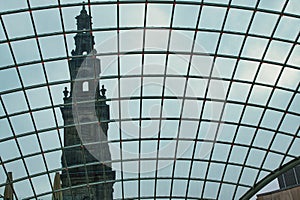 Historic tower viewed through a modern glass dome, contrasting architectural styles in Leeds, UK
