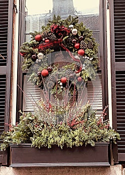 Close-up of window on home in historic town with large pine-cone wreath photo