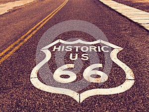 Historic US Route 66 highway sign on asphalt in Oatman, Arizona, United States. The picture was made during a motorcycle road trip