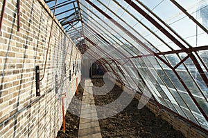 Historic wall glasshouse rebuilt from authentic bricks and iron photo