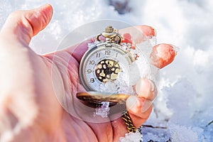 Historic watch in hand, winter background.